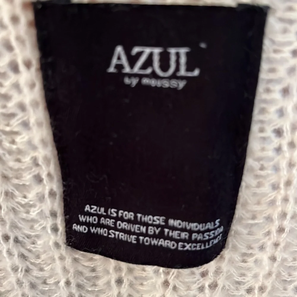 Azul Women’s cream ribbed V neck sweater. There is a little pull on sleeve.